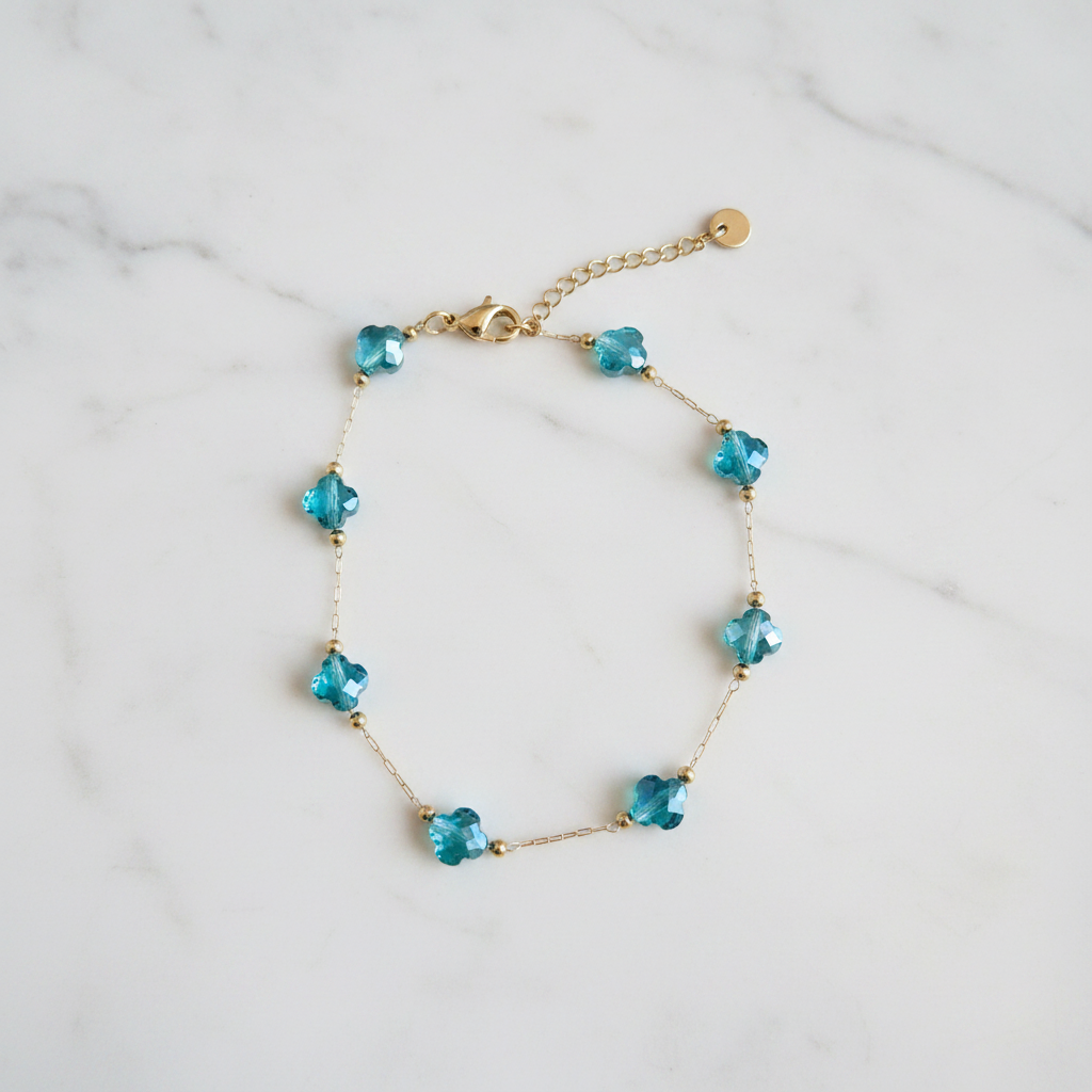 Bracelet doré cristaux turquoise sur marbre blanc